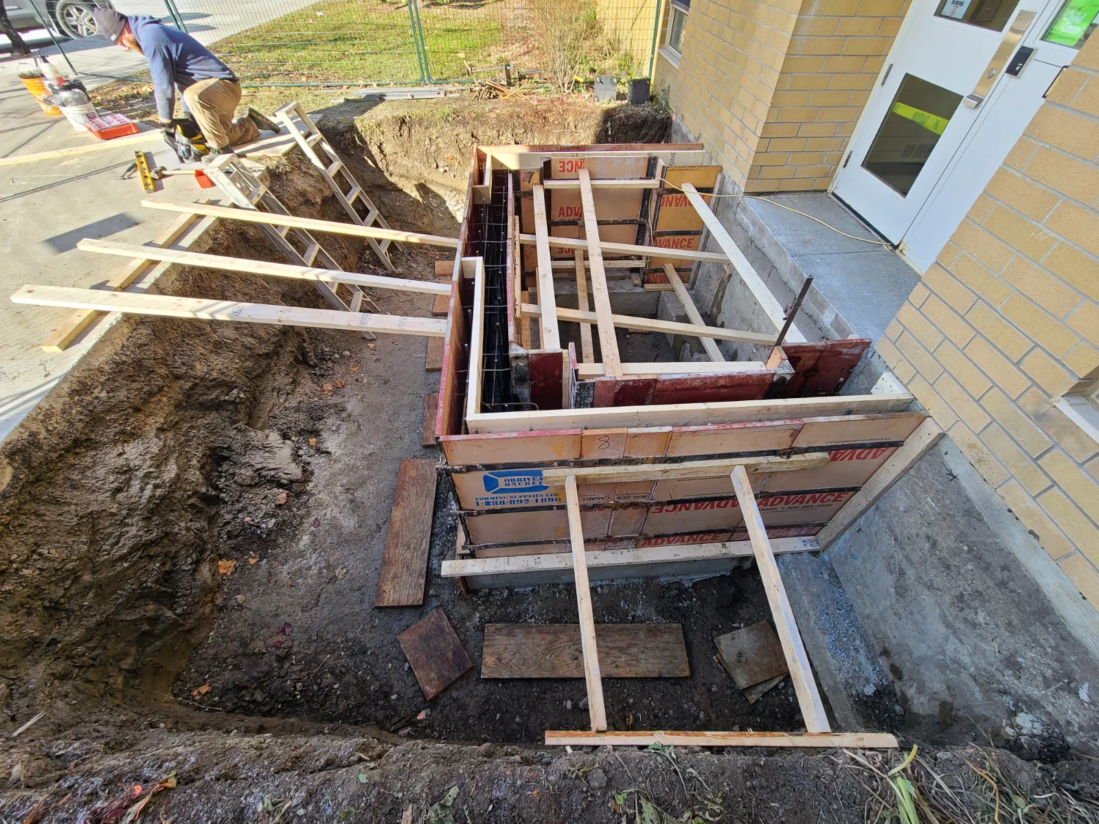 Construction site trench with wooden supports.