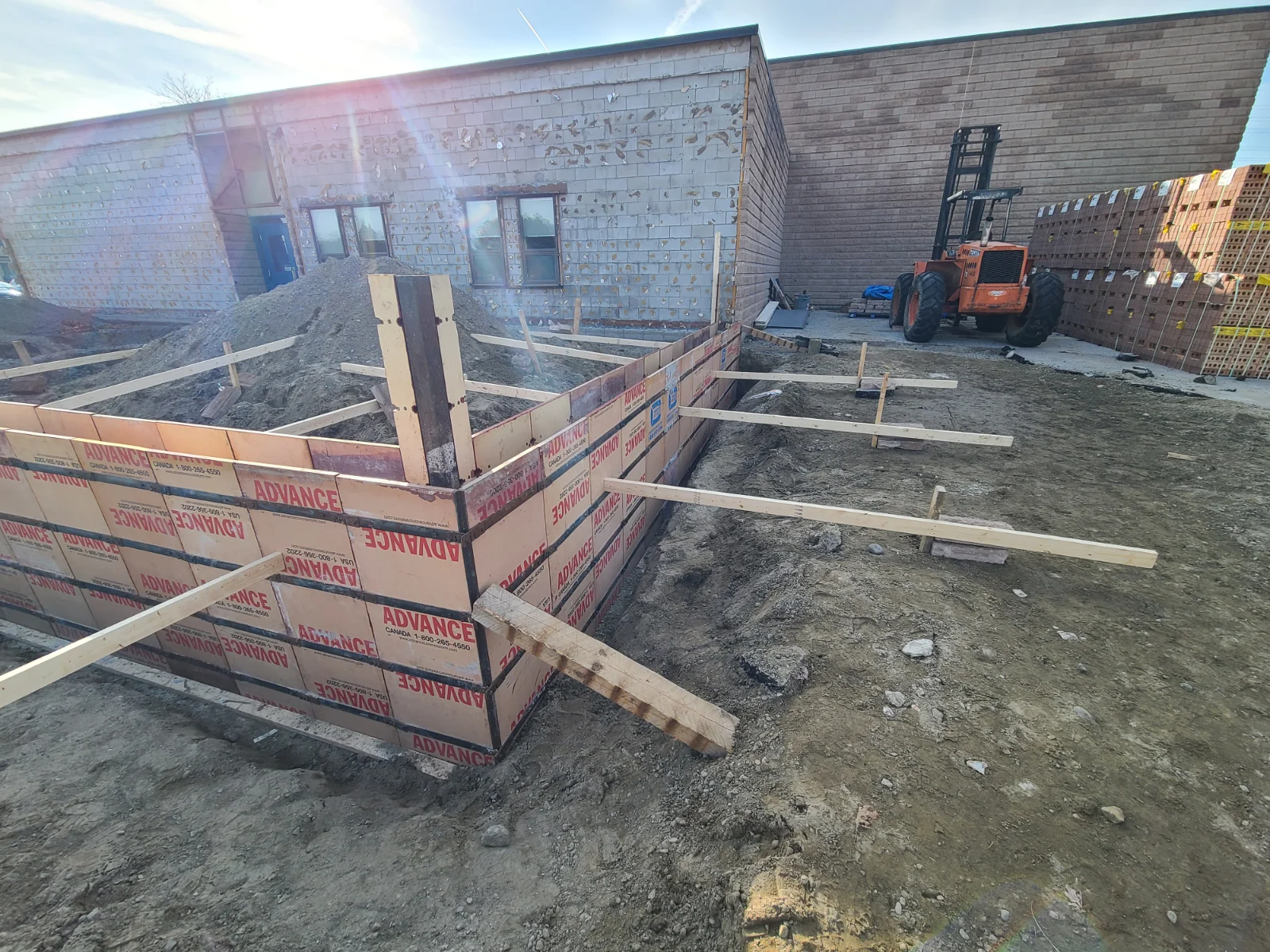 Construction site with foundation forms and forklift