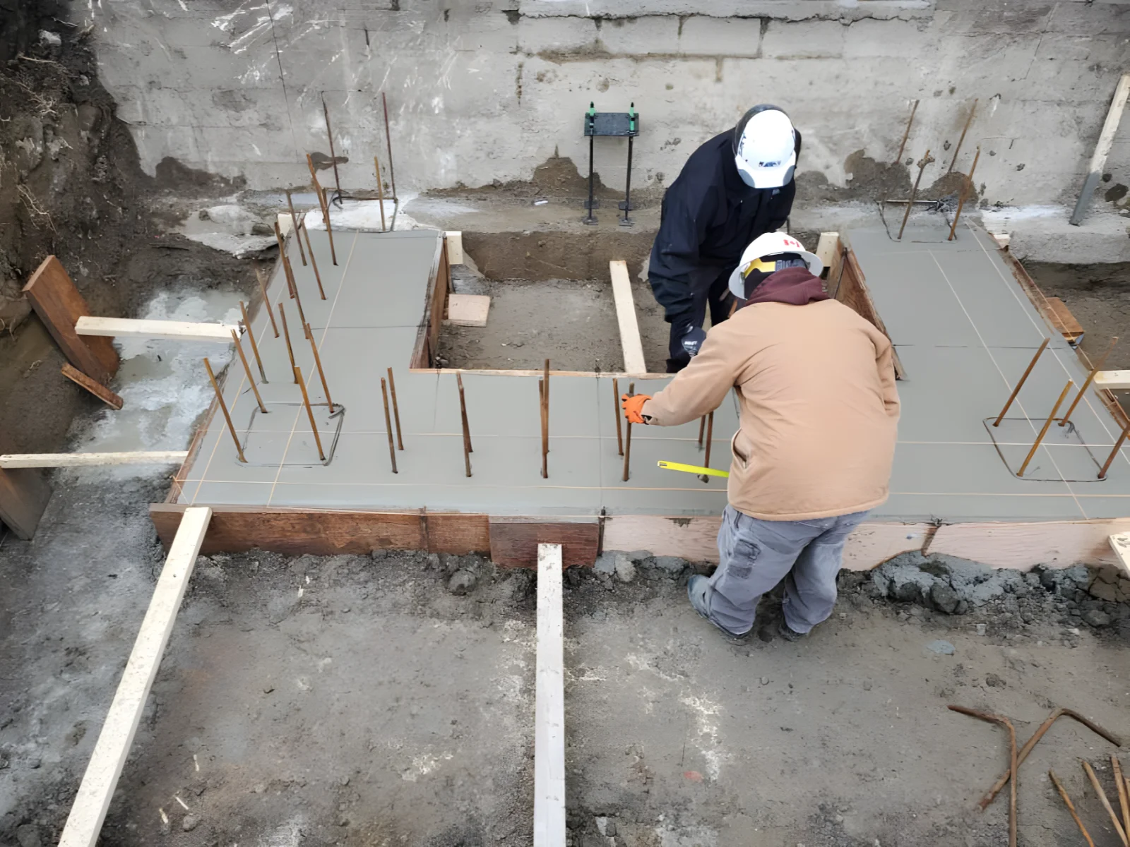 Construction workers leveling concrete foundation.
