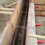 Concrete foundation formwork with reinforcing bars.