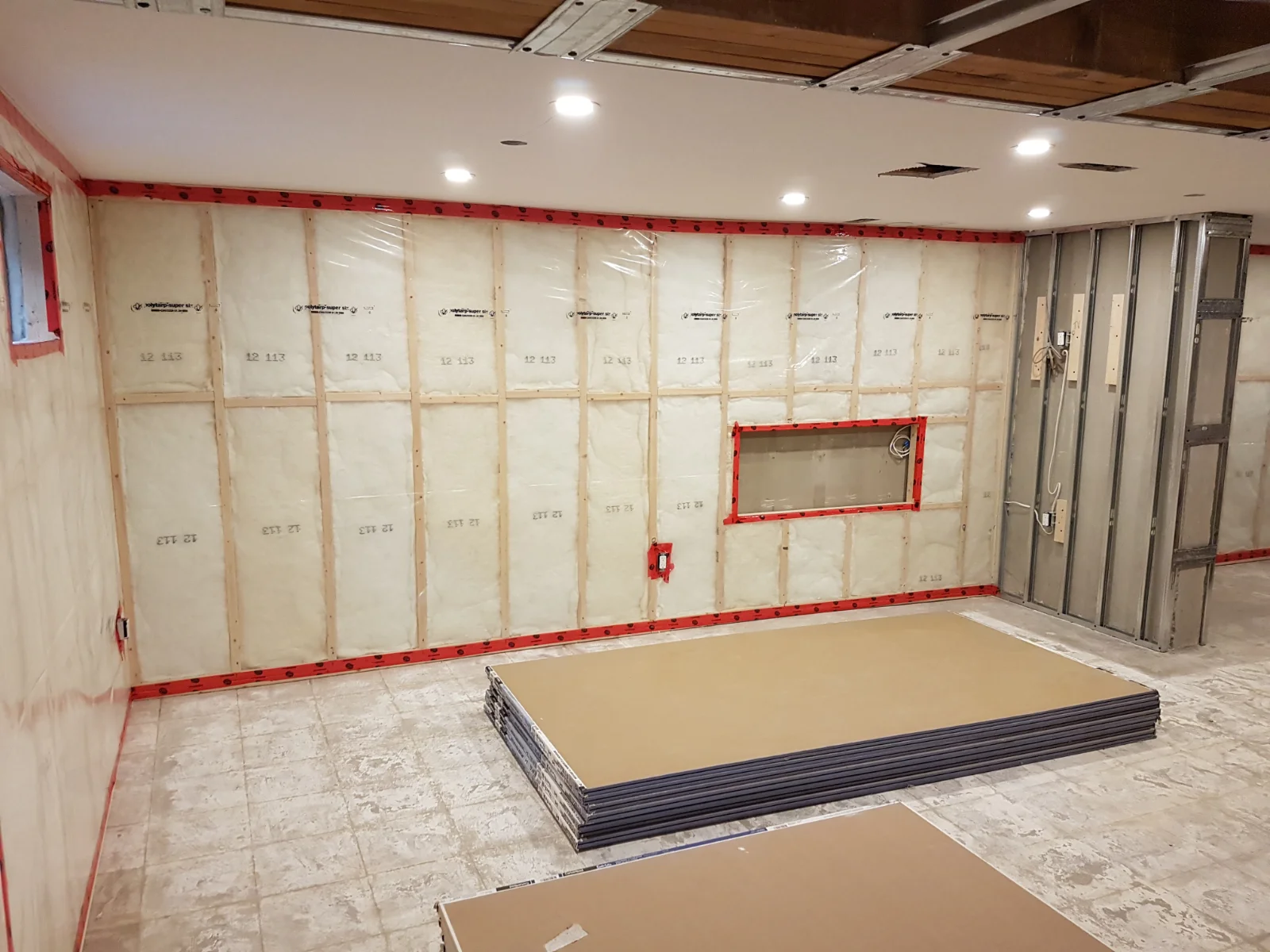 Basement under renovation with insulation and drywall.