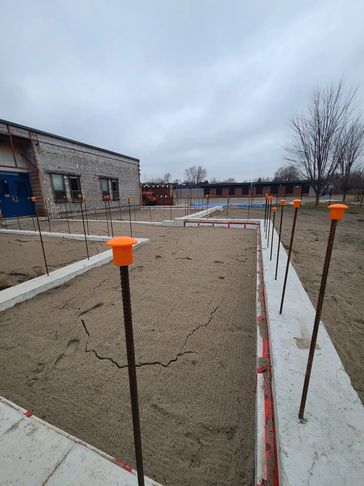 Construction site with rebar and sand foundation.