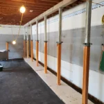 Temporary wall support beams in basement construction site.