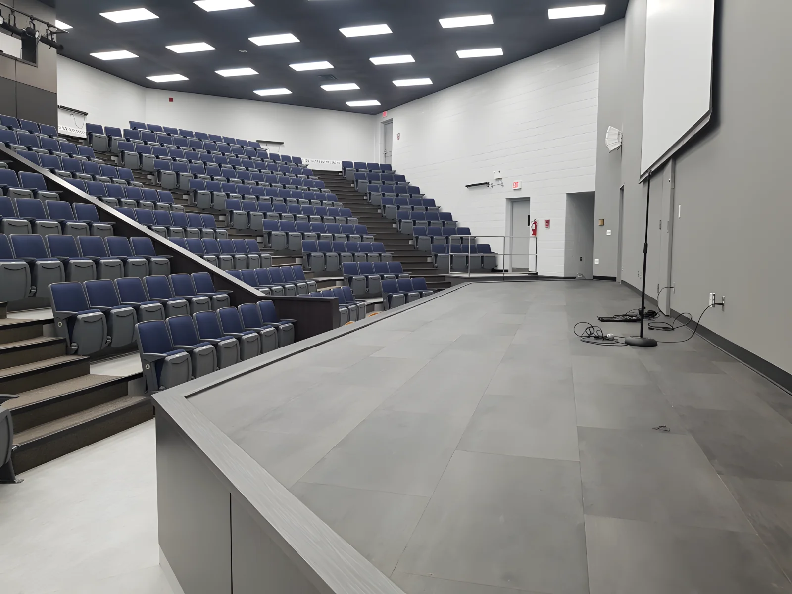 Empty modern lecture hall with tiered seating.