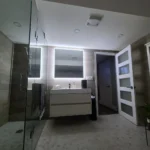 Modern bathroom with illuminated mirror and glass shower