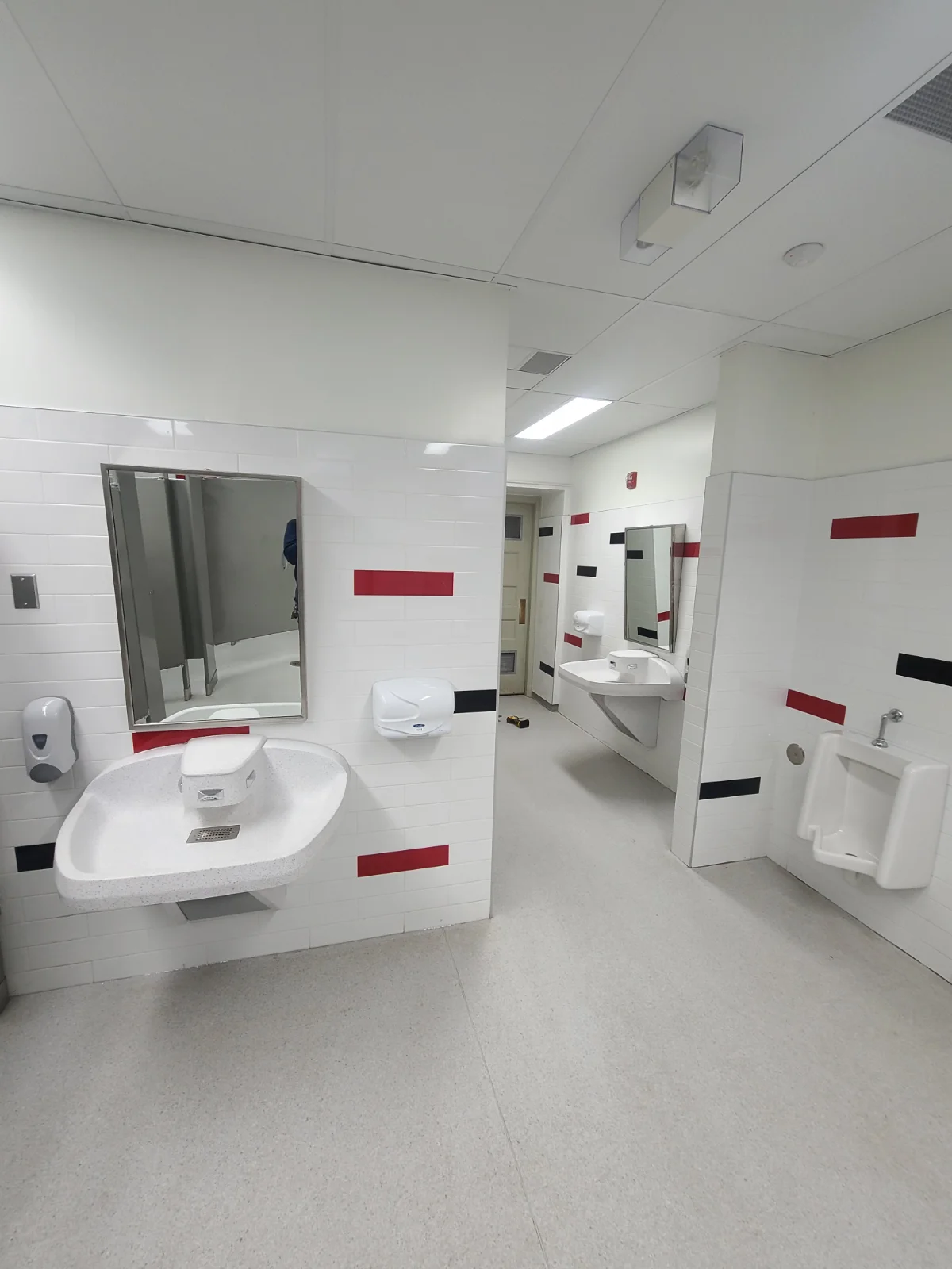 Public restroom with sinks and urinal.