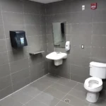 Modern accessible bathroom with sink and toilet.