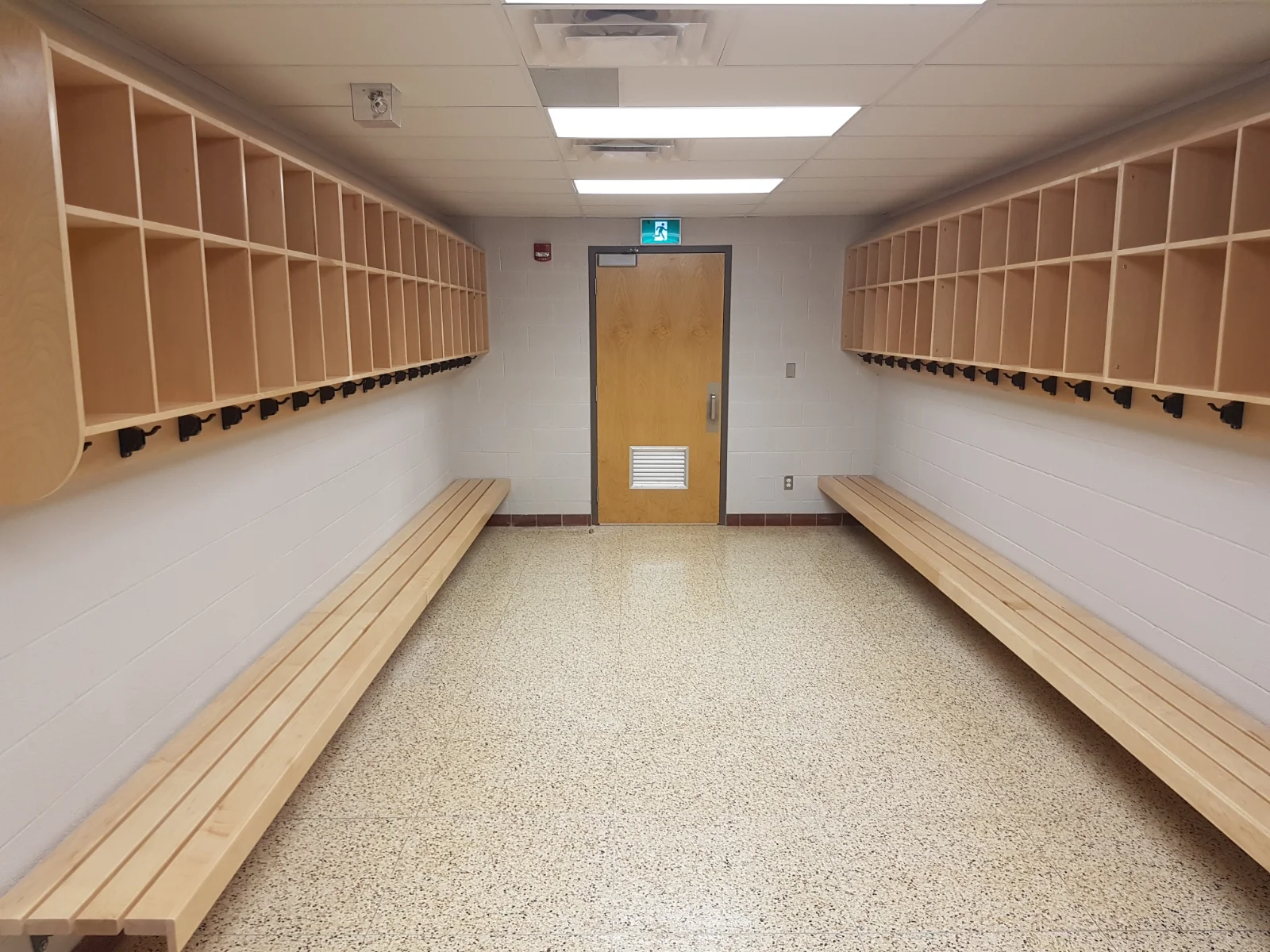 Empty locker room with benches and cubbies.