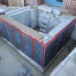 Construction site with foundation and ladder.