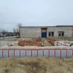 Building under construction with foundation work visible.