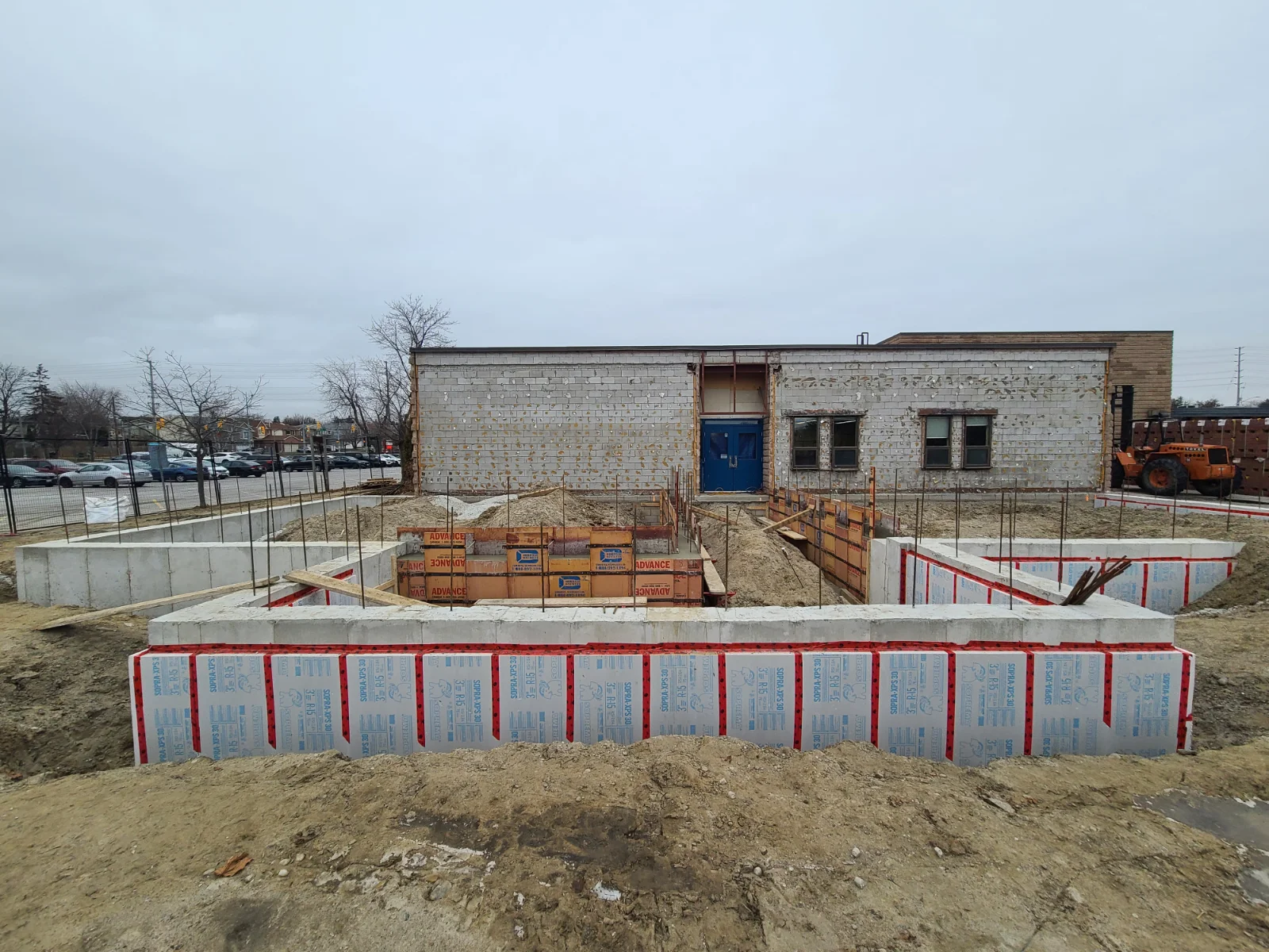 Building under construction with foundation work visible.