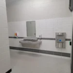 Public restroom with sink and hand sanitizer dispenser.