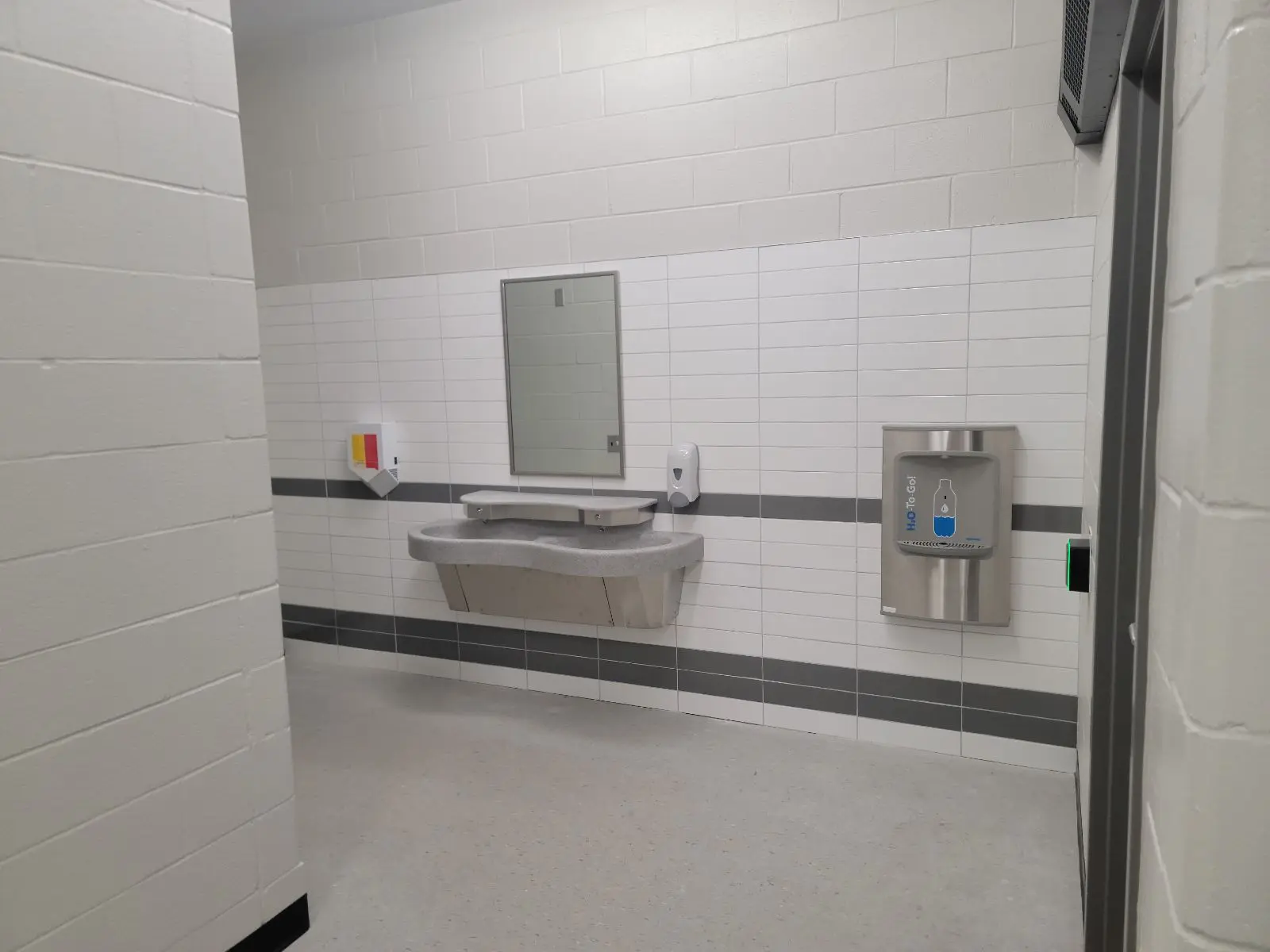 Public restroom with sink and hand sanitizer dispenser.