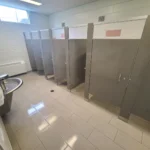 Public restroom with stalls and sinks.