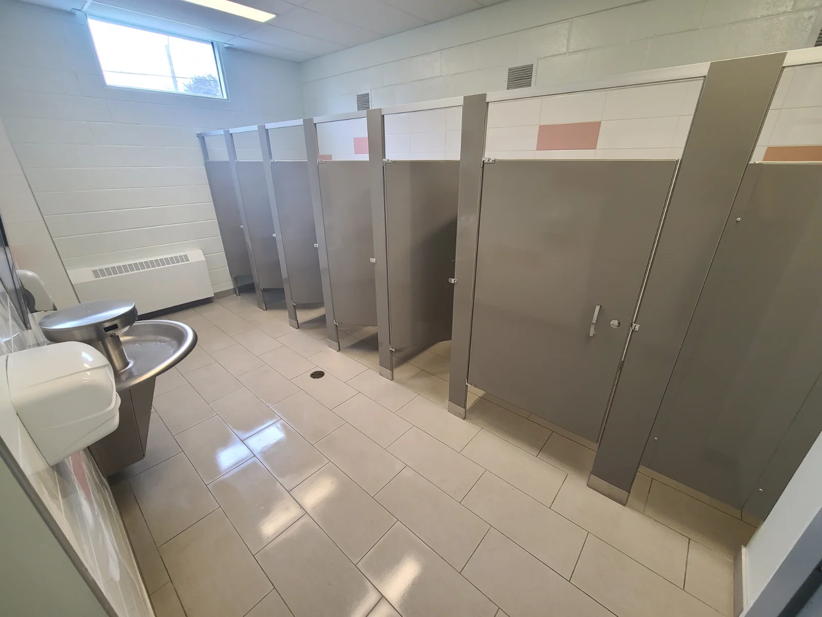Public restroom with stalls and sinks.