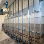 Metal studs and pipes in unfinished construction area.