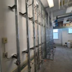 Unfinished wall with exposed metal studs and wiring.