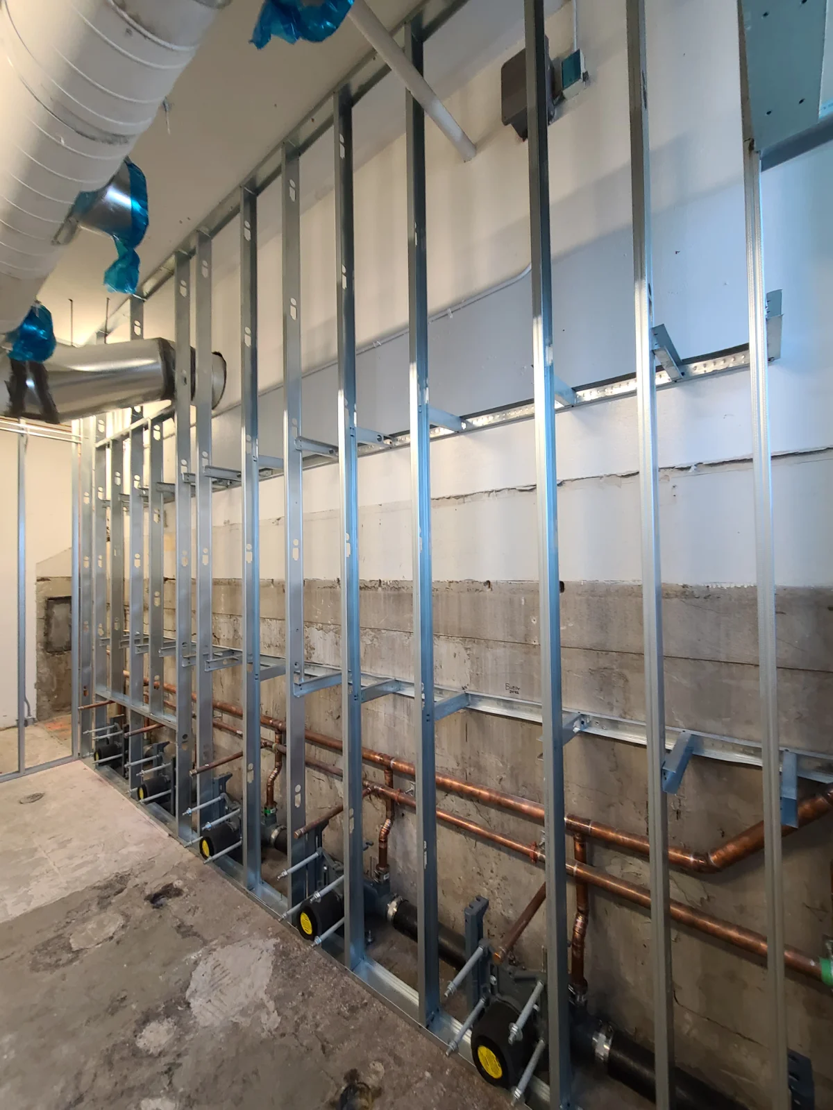 Metal studs and pipes in unfinished construction area.